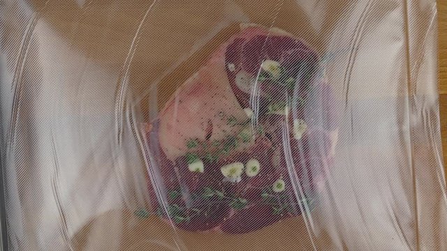 vacuum-packing of a fresh spiced beef shank for sous vide low temperature cooking closeup 4k