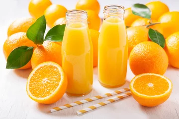 Fotobehang bottles of fresh orange juice with fresh fruits © Nitr