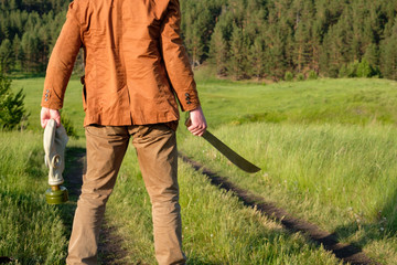 the robber on the road stands with his back in his hand a sword and a gas mask