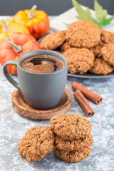 Spicy pumpkin and oatmeal cookies with a cup of coffee, vertical
