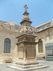 Fototapeta na wymiar Malta La Valletta monument with skulls and cross in inner courtyard