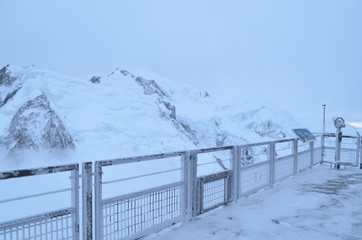 snow covered icy telescope binoculars lookout in snowy alps 