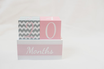 Rosa grauer Monatswürfel 20 Monate 20 months vor weißem Hintergrund	