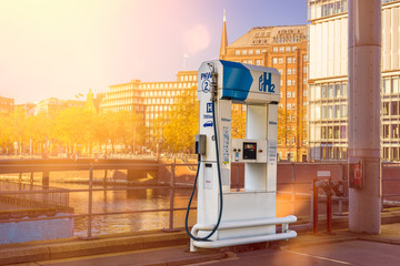 Wasserstoff Tankstelle H2 Tanksäule in der Stadt Hamburg mit Häusern und Sonne im Hintergrund