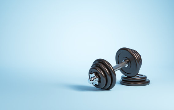 Heavy black professional dumbbell for fitness and bodybuilding with two weight plates on the blue background. Top view.