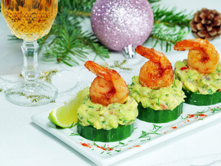 Canape with cucumber, avocado salad and shrimp on white platter on the Christmas table with a glass of bourbon