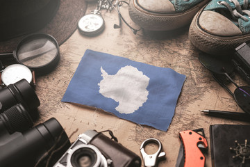 Antarctica Flag Between Traveler's Accessories on Old Vintage Map. Tourist Destination Concept. © natanaelginting