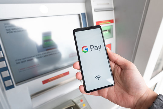 Man holding smartphone with Google Pay logo