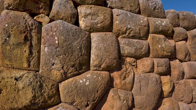 Detail of the stone blocks that form the walls of the citadel of Chinchero, overlooking the walls and the colonial church as background. Cusco Region, Peru