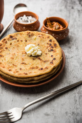 Aloo Paratha / Indian Potato stuffed Flatbread with butter on top. Served with fresh sweet Lassi, chutney and pickle . selective focus