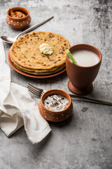 Aloo Paratha / Indian Potato stuffed Flatbread with butter on top. Served with fresh sweet Lassi, chutney and pickle . selective focus