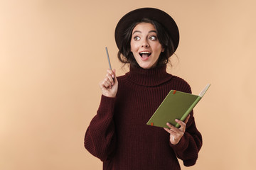 Surprised brunette woman writing notes in notebook