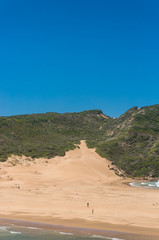 Coastal landscape with grass covered mountain and sand dunes