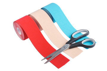 three rolls kinesiology tape for athletes and scissors isolated on white background. Kinesiology taping manipulate nerve receptors and reduces pain in muscles and speeds up the healing process - obrazy, fototapety, plakaty