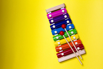 xylophone on a yellow background. wooden children's toy. musical instrument for baby. the child's leisure. space for text. the view from the top.