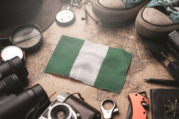 Nigeria Flag Between Traveler's Accessories on Old Vintage Map. Tourist Destination Concept.