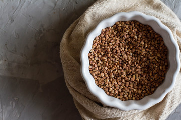 Buckwheat in a white dish on the table. The view from the top. Space for text. delicious and healthy food and nutrition. vitamins for humans.