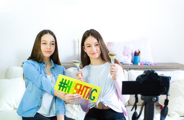 Teen girl blogger cute presenting beauty cosmetic products and broadcasting live video to social...