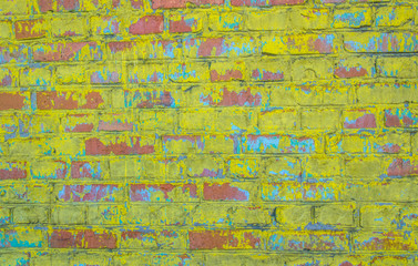 Old weathered brick wall. Peeling cracked paint on red brick