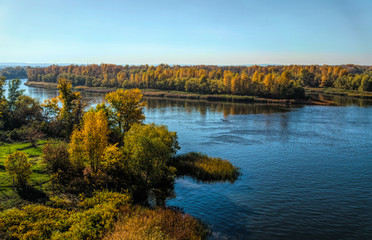 River, blue sky and forest. Picturesque sunny autumn landscape