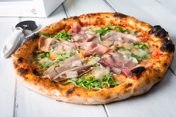 Deliziosa pizza con prosciutto crudo, rucola e scaglie di grana