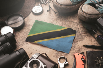 Tanzania Flag Between Traveler's Accessories on Old Vintage Map. Tourist Destination Concept.