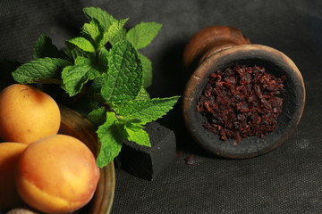 bowl with tobacco for hookah. fruits on a dark background. smoking nargile