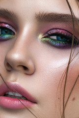 A very close up photo of young model with blue eyes, rainbow eyeshadows and perfect skin. - obrazy, fototapety, plakaty