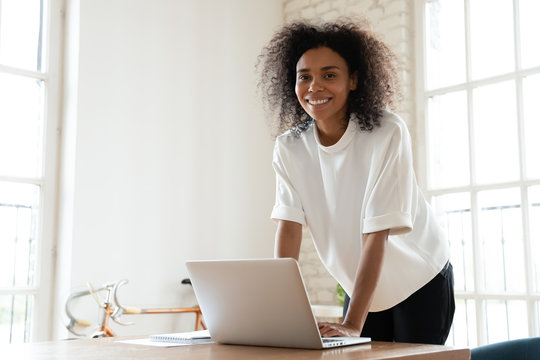 African American Young Business Woman Leaning Over Table.