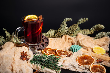 Christmas composition with mulled wine, oranges and branches of spruce on a dark black background. Winter drink. Hot Christmas Mulled Wine.