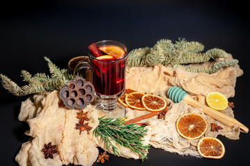 Christmas composition with mulled wine, oranges and branches of spruce on a dark black background. Winter drink. Hot Christmas Mulled Wine.