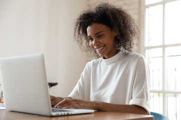 African american international company worker sitting at table with computer.