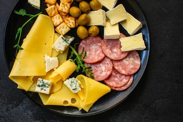 cheese board (different types of cheese plate appetizers , sausage, ham, olives, greens and more)...