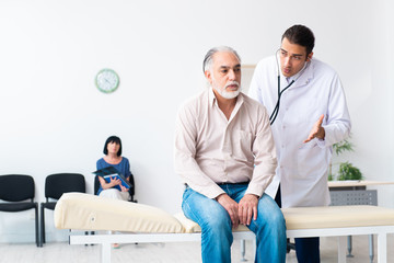 Obraz premium Old couple visiting young male doctor