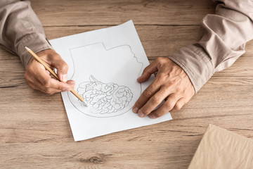 cropped view of retired man with alzheimer disease drawing human head and brain - obrazy, fototapety, plakaty