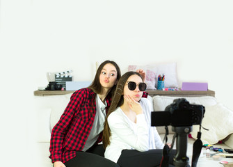 Two teen girls blogger presents beauty products, combs and transmits live video to social networks....