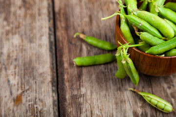 Green peas in a wooden bowl.