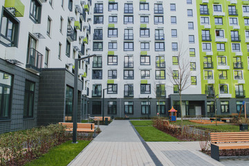 Fototapeta na wymiar new residential quarter of new buildings: a modern playground in the courtyard of an apartment building with a bright facade 1