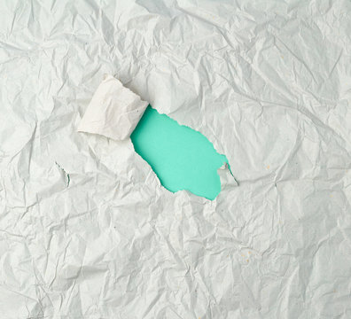 gray crumpled sheet of paper with a hole, green backing