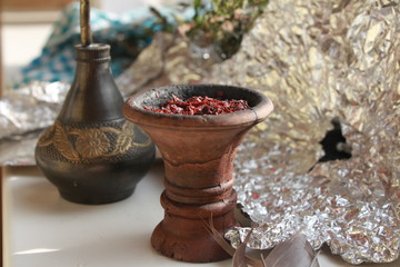 bowl with tobacco for hookah. fruits on a black background. smoking hookah