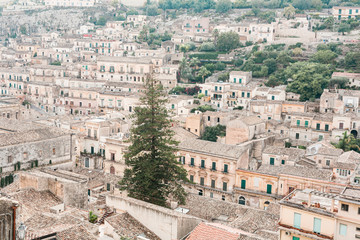 green trees near ancient buildings in modica, Italy