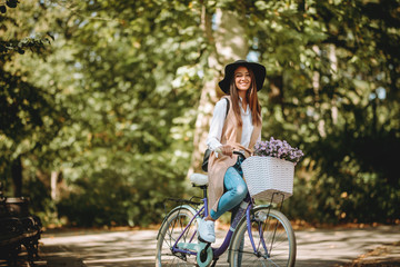 Fototapeta na wymiar Young beautiful woman riding a bicycle in a park. Active people. Outdoors