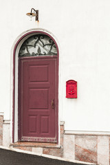 Fototapeta na wymiar building with red door near vintage post box
