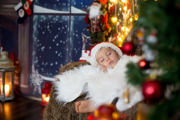 Beautiful toddler child, baby boy, sleeping on Christmas eve at home
