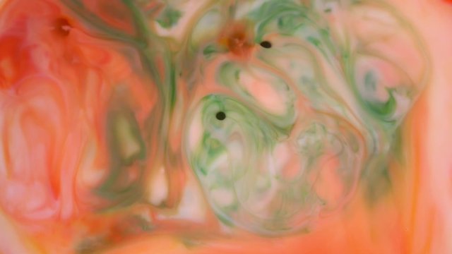 4K footage. Ink in water. Red and orange ink reacting in water creating abstract background.