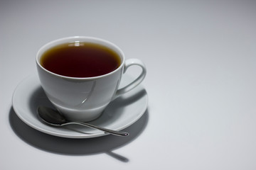 A mug of tea on a saucer. On white background.