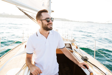 Handsome young amazing man outdoors on yacht in sea.