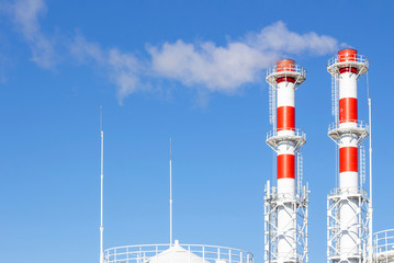 Factory plant smoke stack over blue sky background. Thermal condensing power plant. Energy generation and air environment pollution industrial scene