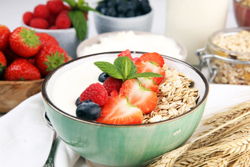 Tasty homemade granola served on table. Healthy breakfast with a bowl of oatmeal with banana, blueberries, strawberries and healthy food for Breakfast