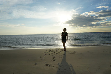 Asain woman walking on the beach waitting for sunset at Thailand
